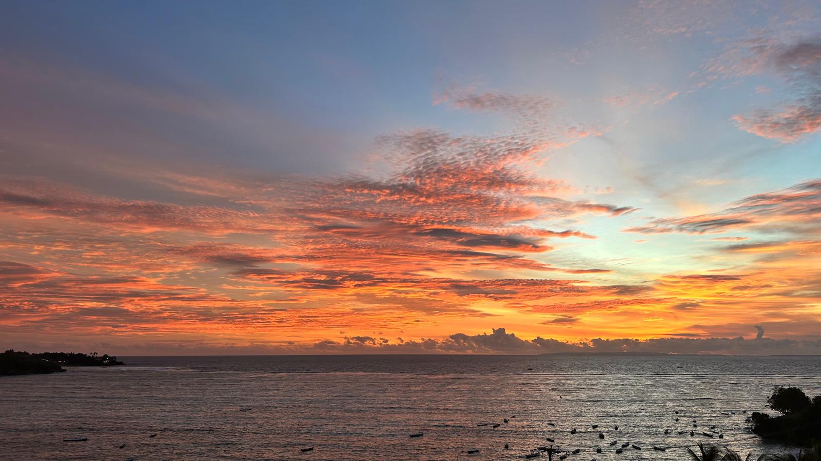 View of sunset over the ocean with orange clouds