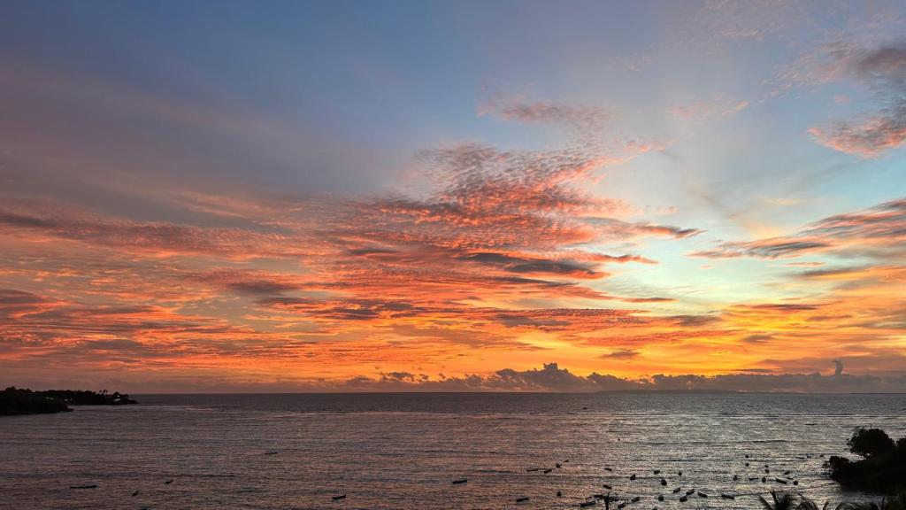 View of sunset over the ocean with orange clouds